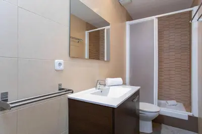 a bathroom with a sink and a toilet and a mirror at Canela Homes BARCELONA VALÈNCIA in Barcelona
