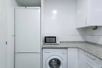 a kitchen with a washing machine and a refrigerator at Canela Homes BARCELONA VALÈNCIA in Barcelona