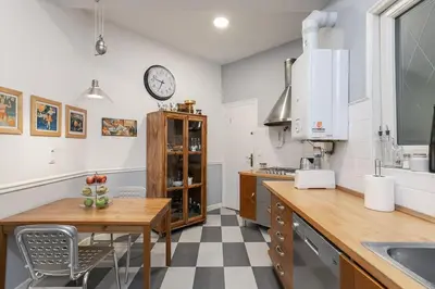 a kitchen with a table and a clock on the wall at Canela Homes BARCELONA CLASSIC in Barcelona