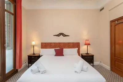 a bedroom with a large white bed with two lamps at Canela Homes BARCELONA CLASSIC in Barcelona