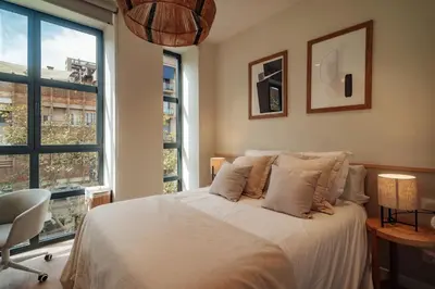 a bedroom with a bed and a large window at Casa Morera in Barcelona