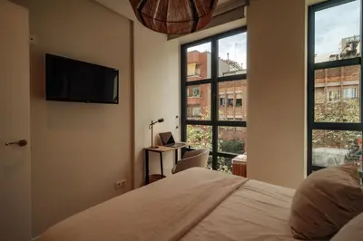 a bedroom with a bed and a flat screen tv at Casa Morera in Barcelona