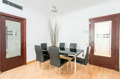 a dining room with a black table and black chairs at Canela Homes BARCELONA MONUMENTAL in Barcelona