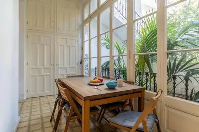 a dining room with a table and a large window at Canela Homes BARCELONA PATIO in Barcelona