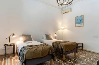 a hotel room with two beds and a chandelier at Canela Homes BARCELONA PATIO in Barcelona