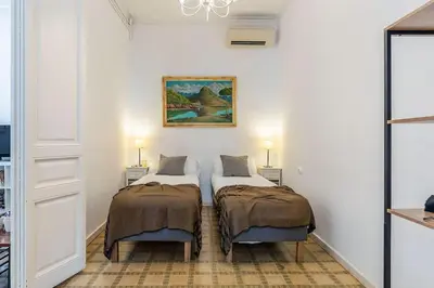 a room with two beds and a painting on the wall at Canela Homes BARCELONA PATIO in Barcelona