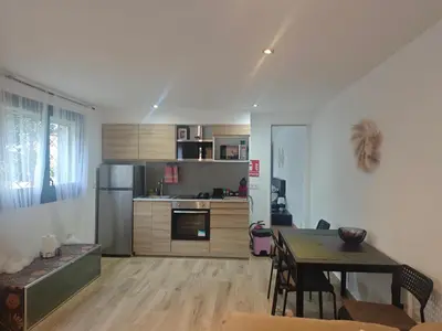 a living room with a table and a kitchen at INSPIRA MAISON Montaña y Mar in Teià