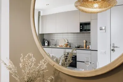 a kitchen with white cabinets and a mirror at Casa Plaza in Barcelona
