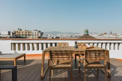 a wooden table and chairs sitting on a balcony at Casa Plaza in Barcelona