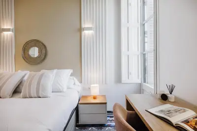a bedroom with a bed and a desk and a window at Casa Ribera in Barcelona