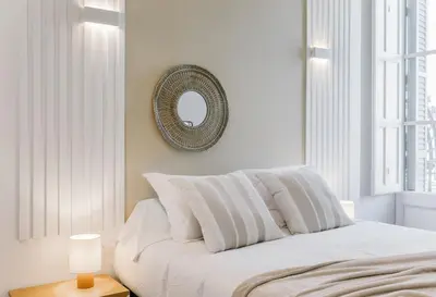 a bedroom with a bed with a mirror on the wall at Casa Ribera in Barcelona