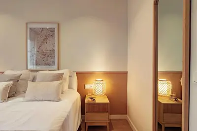 a bedroom with a bed and two night stands with lamps at Casa Tamarita in Barcelona
