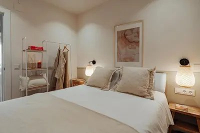 a bedroom with a white bed and two lamps at Casa Tamarita in Barcelona