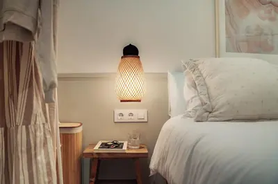 a bedroom with a bed and a table with a lamp at Casa Tamarita in Barcelona