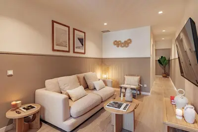 a living room with a white couch and two tables at Casa Tamarita in Barcelona