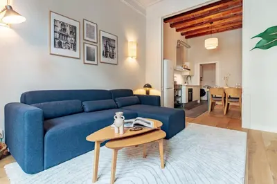 a living room with a blue couch and a table at Casa Atlas in Barcelona