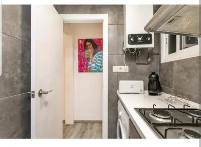 a kitchen with a picture of a woman on the wall at Apartamento BB in Hospitalet de Llobregat