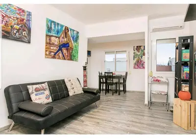 a living room with a black couch and a table at Apartamento BB in Hospitalet de Llobregat