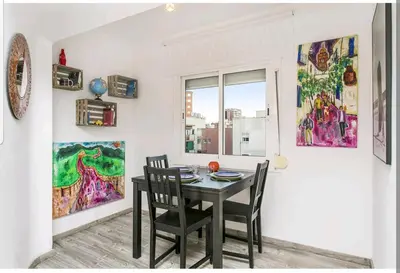 a dining room with a table and chairs and a window at Apartamento BB in Hospitalet de Llobregat
