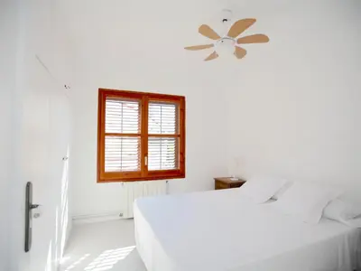 a white bedroom with two beds and a window at Apartamento nuevo muy luminoso in La Crehueta