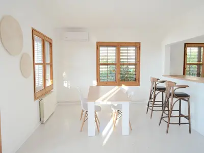 a white kitchen with a white table and chairs at Apartamento nuevo muy luminoso in La Crehueta