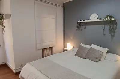 a bedroom with a white bed and a window at Apartamento Gran Via para 6 en el centro de Premià in Premiá de Mar