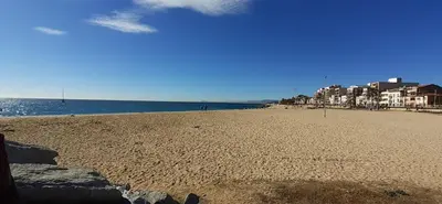a sandy beach with buildings and the ocean at Apartamento Gran Via para 6 en el centro de Premià in Premiá de Mar