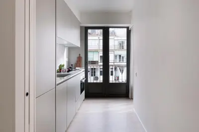 a kitchen with white cabinets and a black door at Casa Mercader - Simaba Group in Barcelona