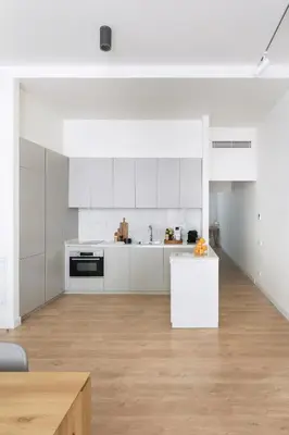 an empty kitchen with white cabinets and a table at Casa Mercader - Simaba Group in Barcelona