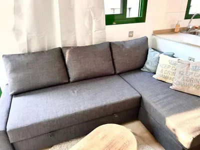 a gray couch in a living room with a table at Barcelona Raval in Barcelona