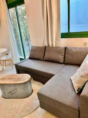 a living room with a couch and a window at Barcelona Raval in Barcelona