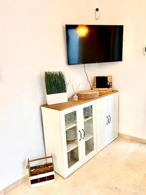 a tv on a wall with a white cabinet at Barcelona Raval in Barcelona