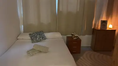 a small bedroom with two beds and a night stand at Tranquilo y céntrico in Barcelona