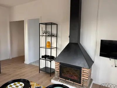 a fireplace in a living room with a tv at Ático gran terraza cerca BCN in Castelldefels
