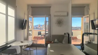 a living room with a view of a room with a table and chairs at Top Studio with Terrace in Barcelona