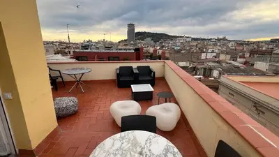 a balcony with chairs and tables and a view of a city at Top Studio with Terrace in Barcelona