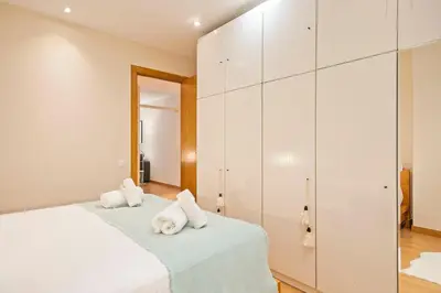a bedroom with white cabinets and a bed with towels at Winahost Barcelona Provenza in Barcelona
