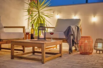 a living room with a couch and a table with wine glasses at El Niu Apartamentos con terraza Camp Nou in Hospitalet de Llobregat