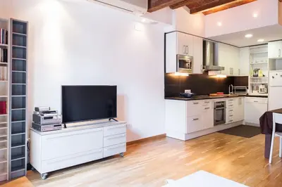 a kitchen with white cabinets and a flat screen tv at Moderno y auténtico en el corazón de Poble Sec in Barcelona