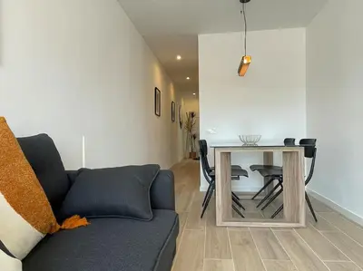 a living room with a couch and a table with chairs at Jordi home 15 minutes to center by train in Sant Adria de Besos