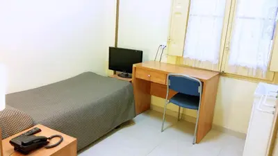 a bedroom with a desk and a bed with a computer at Hostal Capitol Ramblas in Barcelona
