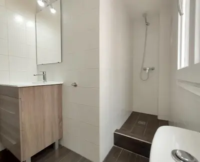a white bathroom with a sink and a shower at Barceloneta Beach Apartments in Barcelona