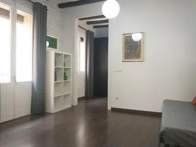 a living room with white walls and a wooden floor at Barceloneta Beach Apartments in Barcelona