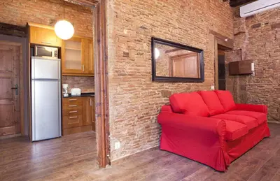 a red couch in a room with a brick wall at El Born - Barcelona Center Apartment in Barcelona