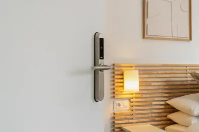 a white bedroom with a white bed and a window at Livinn House - Self Check in in Hospitalet de Llobregat