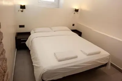 a small white bed in a small room at Barceloneta Apartment in Barcelona