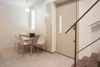 a dining room with a table and white chairs at Barceloneta Apartment in Barcelona