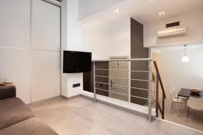 a living room with a couch and a tv and a table at Barceloneta Apartment in Barcelona