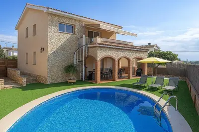 a villa with a swimming pool in front of a house at Catalunya Casas Cozy beach town villa for 8 - no car necessary! in Pineda de Mar