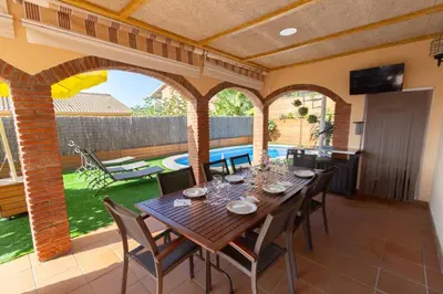 a dining room with a table and chairs on a patio at Catalunya Casas Cozy beach town villa for 8 - no car necessary! in Pineda de Mar